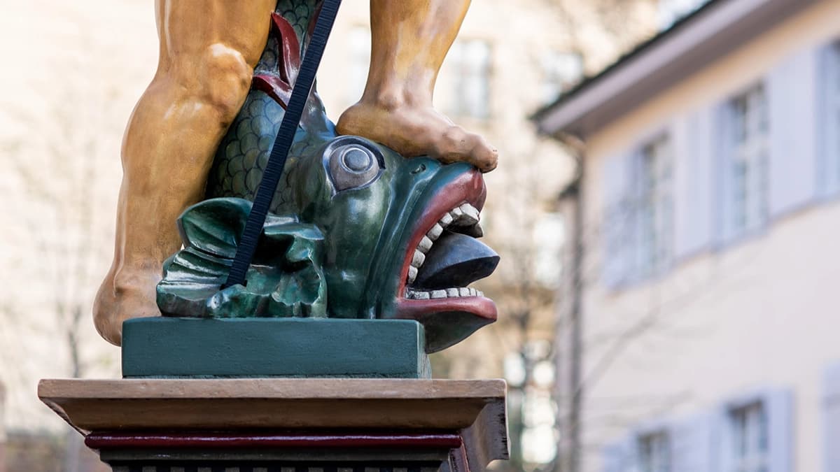 The statue of a fish at a fountain in Basel's old town.