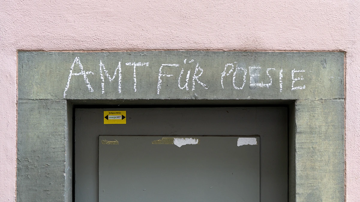 Kreidezeichnung "Amt für Poesie" an einer Hauswand in Zürich.