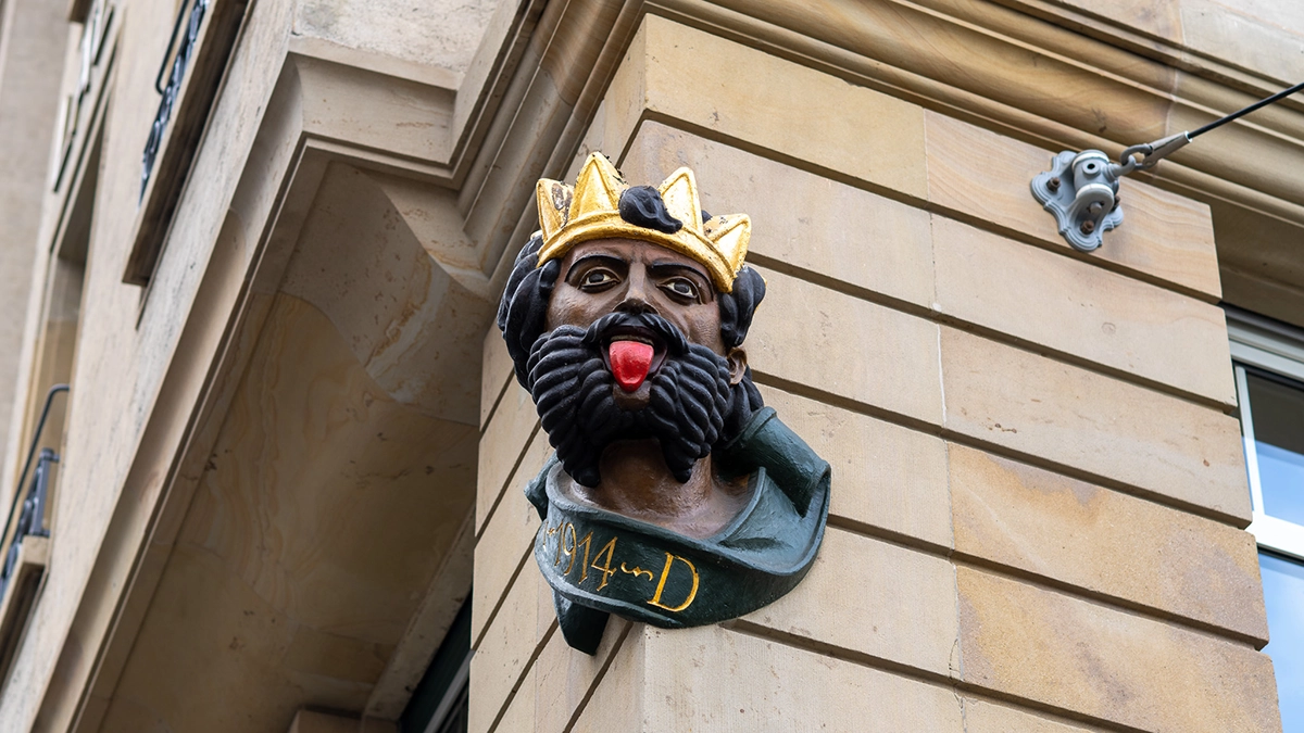 Deine Augen lasern in Basel bei YOUSEE: Detail auf der Front eines Gebäudes - der König streckt die Zunge heraus.